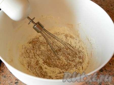 Постепенно всыпать муку, смешанную с разрыхлителем. Тесто получится мягким, вязким.
