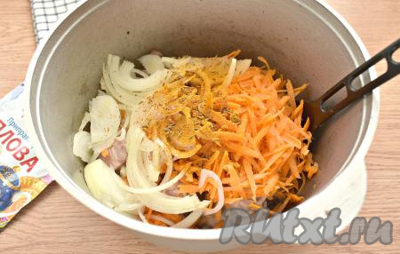 Морковь с луком выкладываем в казан к обжаренным кусочкам куриных бёдер. Всыпаем приправу. Обжариваем курицу вместе с овощами 5 минут, периодически перемешивая.
