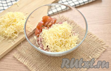 Сыр твёрдых сортов натираем на мелкой (или средней) тёрке. Половину сыра перекладываем в миску с колбасой и помидорами.