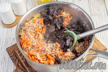 Добавьте чернослив, перемешайте.&nbsp;Накройте гречневую кашу крышкой и оставьте минут на 10-15 настояться.