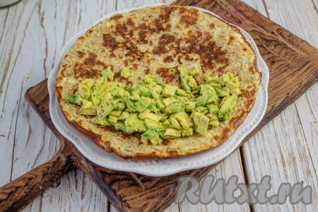 Готовый овсяноблин переложите на блюдо. На одну половину блина выложите размятый авокадо, смешанный с лимонным соком.