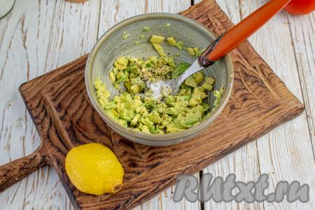 Авокадо разрежьте пополам, достаньте косточку. Из половинки авокадо при помощи ложки достаньте мякоть и, если авокадо очень спелый, то разомните его вилкой. Мне попался не совсем мягкий авокадо, поэтому я мякоть нарезала на очень мелкие кусочки, а затем размяла вилкой. Добавьте к мякоти авокадо сок лимона, немного соли и молотого чёрного перца, перемешайте.