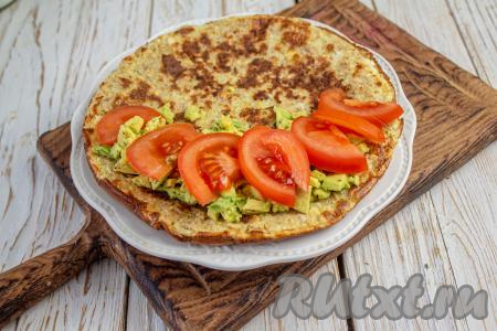 Поверх авокадо распределите дольки помидора.