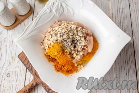 Посолите, добавьте специи для курицы и чёрный молотый перец. Перемешайте фарш и оставьте на 5-10 минут, чтобы хлопья набухли. Если не используете готовый набор специй для курицы, тогда их можно заменить на такие специи: куркума, сладкая молотая паприка, карри, прованские травы, взяв по 1/4 чайной ложки каждой из этих специй, или добавьте специи по вашему вкусу.