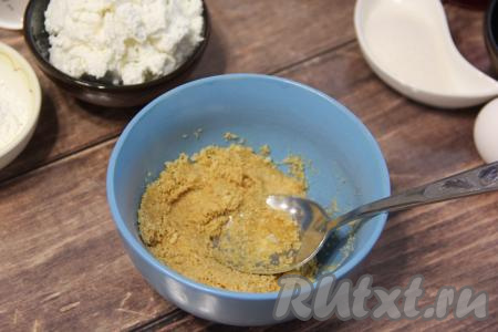 Соединить крошку из печенья и растопленное масло, тщательно перемешать столовой ложкой.