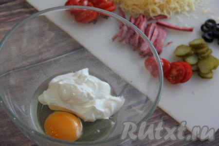 В отдельной миске соединить яйцо и сметану.