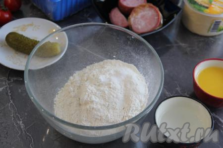 Когда всё для начинки готово, можно приступать к замешиванию бездрожжевого теста для пиццы. Для этого нужно соединить в миске просеянную муку и соль.
