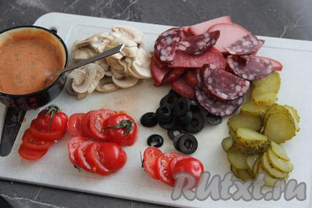 Вначале займёмся начинкой, для этого огурчик и помидоры нужно нарезать на кружочки. Колбасу (у меня - колбасное ассорти) нарезать на кружочки или полукружочки. Сыр натереть на тёрке. Маслины нарезать на колечки, шампиньоны - на тонкие пластины. В отдельной посуде соединить кетчуп и майонез, можно добавить сухие травы, перемешать.