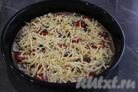 Посыпать пиццу сверху натёртым сыром.