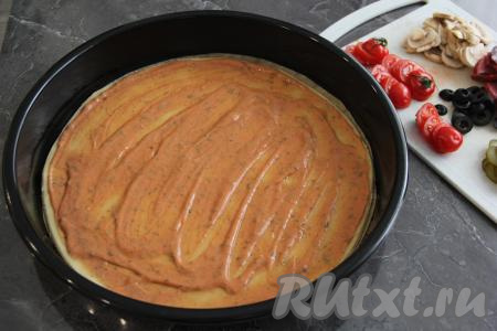 Переложить основу пиццы на противень. Я дно противня застелила пергаментом. Смазать основу заранее подготовленным соусом из кетчупа и майонеза.