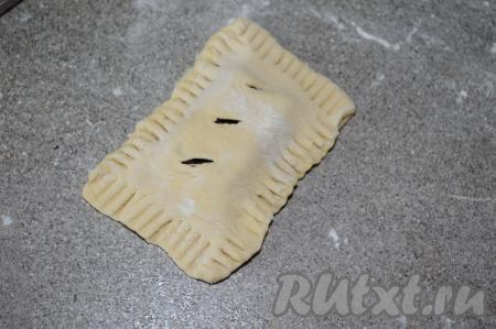 Вилкой пройтись по периметру слойки, тщательно прижимая края теста. Аналогично сформировать все слойки.