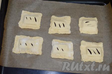 Противень застелить бумагой для выпечки. Если не уверены в качестве бумаги, то обязательно смажьте её растительным маслом. У меня бумага с добавлением силикона, к ней выпечка не пристаёт, поэтому дополнительно смазывать бумагу маслом я не стала. Выложить на бумагу сформированные слойки с шоколадом.