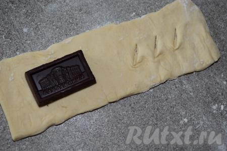 Мысленно разделить каждый прямоугольник на две части. На одну часть теста выложить кусочек шоколада. А на другой части теста сделать 3 небольших разреза острым ножом, как на фото.