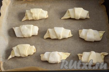 Выложить заготовки рогаликов на противень, застеленный бумагой для выпечки. Я использую бумагу с добавлением силикона, к ней выпечка не прилипает. Если вы не уверены в качестве своего пергамента, то лучше дополнительно смазать пергамент растительным маслом, а потом выложить рогалики.