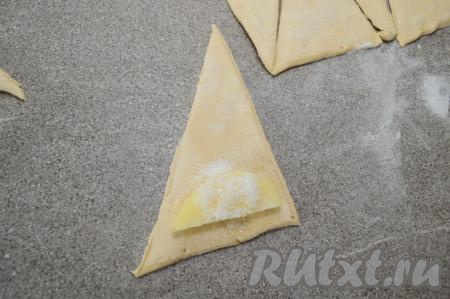 Яблоко, очищенное от кожуры и семечек, нарезать на достаточно тонкие дольки. На основание каждого треугольника выложить дольку яблока, присыпать 1/3 чайной ложки сахара.