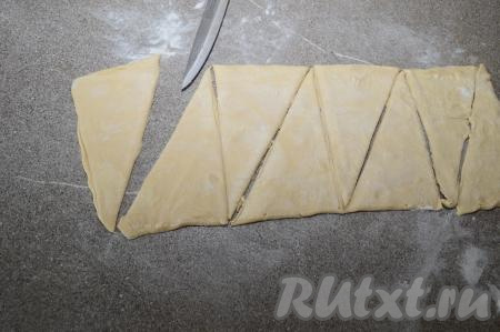 Раскатанное тесто разделить на 4 прямоугольника. А затем каждый прямоугольник разрезать по диагонали на 2 треугольника. В результате у меня получилось 8 треугольников (именно 8 слоёных рогаликов я и испекла).