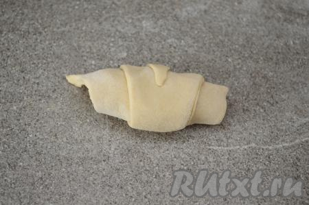 Начиная с основания треугольника, свернуть заготовку в рулетик. Аналогично сформировать все 8 рогаликов с яблоками.