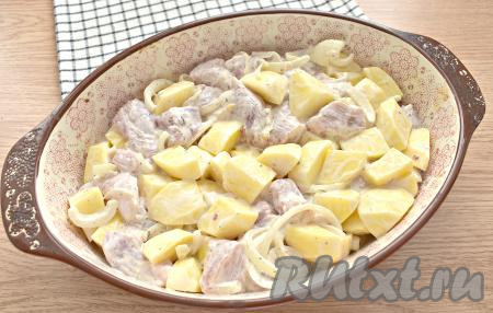 Перемешиваем кусочки свинины с картошкой и луком так, чтобы каждый кусочек картофеля покрылся майонезом. Смазываем форму для запекания растительным маслом и выкладываем в неё картошку со свининой и луком.