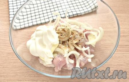 К луку и кусочкам свинины добавляем майонез, соль, приправу для свинины и молотый чёрный перец, хорошо перемешиваем.