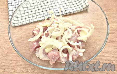 Нарезаем очищенную луковицу полукольцами и перекладываем в миску со свининой.
