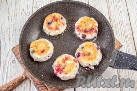 Переверните аккуратно сырники и жарьте ещё несколько минут с другой стороны, тоже под крышкой.&nbsp;