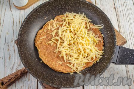 Затем на половину овсяноблина выложите натёртый сыр.&nbsp;