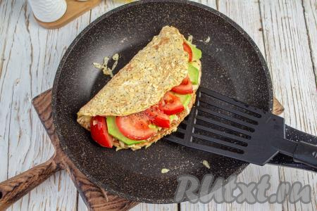 Прикройте начинку из авокадо, сыра и помидоров свободной стороной овсяноблина и готовьте под крышкой ещё 1-2 минуты.&nbsp;