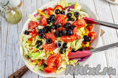 Помидоры черри нарежьте на 2-4 части, в зависимости от их размера. Маслины без косточки разрежьте пополам, добавьте их вместе с помидорами в салат. Влейте ещё треть заправки и перемешайте.