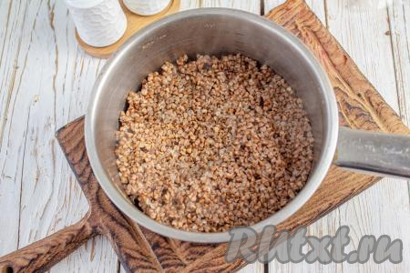 Гречневую крупу промойте, удаляя испорченные зёрнышки, переложите в сотейник, затем залейте 150 мл чистой воды комнатной температуры. Поставьте на огонь, а после закипания отварите в течение 12-15 минут (до полуготовности гречки), затем дайте крупе полностью остыть (если вдруг останется вода, полностью её слейте, переложив гречку в сито).