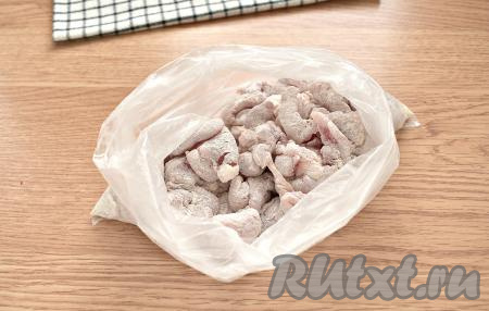 Перекладываем нарезанную свинину в целлофановый пакет. Всыпаем туда же муку и тщательно встряхиваем - такой кулинарный приём позволит равномерно распределиться муке на кусочках свинины.