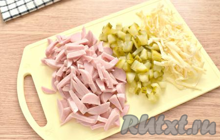 Колбасу (или молочные сосиски) нарезаем на тонкие брусочки, огурцы - на маленькие кубики, сыр натираем на тёрке.