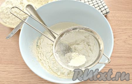 В получившуюся смесь небольшими частями добавляем просеянную муку. После каждого добавления муки перемешивайте смесь с помощью вилки. Когда ингредиенты соберутся в комок, перемешивать тесто продолжайте уже руками.