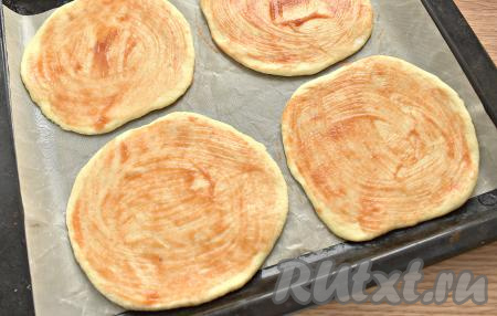 Из колобков раскатываем лепёшки (примерный диаметр 15 см). Заготовки для пиццы раскладываем на противень, застеленный пергаментом, и смазываем томатным соусом (или кетчупом).