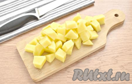 Очищаем картошку, нарезаем её на средние кубики и перекладываем в куриный бульон.