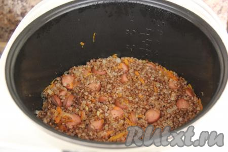 По звуковому сигналу открыть крышку мультиварки и перемешать гречку с сосисками.