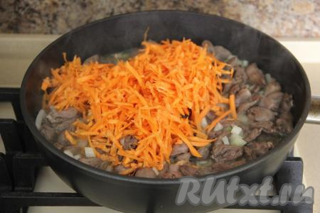 Затем к луку и куриным сердечкам добавить натёртую морковку.&nbsp;