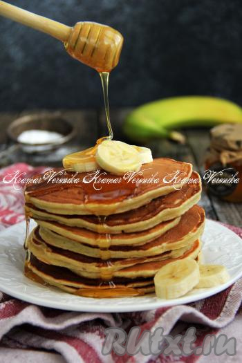 Пышные, нежные панкейки подать к столу тёплыми, дополнив, например, мёдом и кусочками банана.