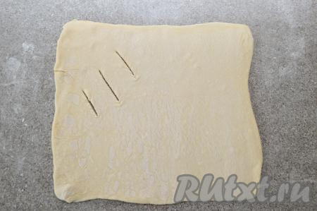 На присыпанной мукой поверхности раскатать вначале один прямоугольник в квадрат толщиной, примерно, 2 мм. В одном углу квадрата острым ножом сделать 3 надреза на тесте.