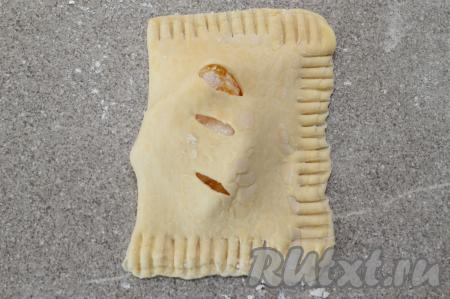 Стороной с надрезами накрыть сторону с начинкой, формируя прямоугольник. Затем при помощи вилки пройдитесь по трём сторонам заготовки и аккуратно прижмите их вилкой. Если вилка будет приставать к тесту, то припорошите вилку мукой.