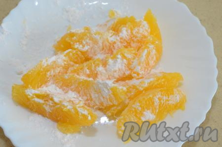 Подготовленные дольки апельсина смешать с крахмалом (я просто присыпаю крахмалом так, чтобы он равномерно покрыл каждую дольку). Крахмал слегка желирует апельсиновый сок в процессе выпечки, поэтому он не будет сильно вытекать и не позволит размокнуть тесту.
