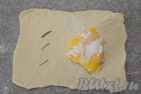 На сторону, противоположную стороне с разрезами, выложить несколько кусочков апельсина, смешанных с крахмалом, присыпать 1 чайной ложкой сахара. У меня апельсин был несладкий, но этого количества сахара оказалось вполне достаточно.