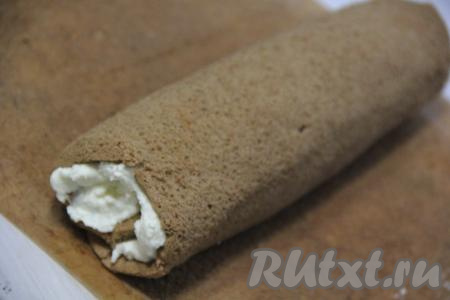 Свернуть корж в рулет и завернуть его в фольгу (или пергамент). Убрать в таком виде шоколадный бисквитный рулет с творожным кремом в холодильник на ночь для пропитки.