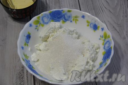 Горячий корж свернуть прямо с ковриком (или пергаментом) в рулет и оставить на 10-15 минут. А пока займёмся кремом для шоколадного бисквитного рулета, для этого нужно в достаточно объёмную ёмкость выложить творог и сахар, пробить погружным блендером.