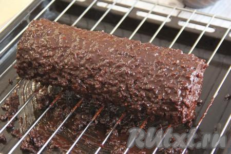 Готовый рулет достать из фольги, выложить на решётку. Теперь его можно присыпать сахарной пудрой или полить шоколадом и можно подавать к столу. Я решила покрыть рулет ганашом. Для приготовления ганаша нужно в сотейник влить сливки, поставить на огонь, довести до кипения, не давая закипеть, снять с огня. Выложить в горячие сливки кусочки шоколада и перемешать до полного растворения шоколада, ганаш получится однородным, добавить в него орехи, предварительно измельчённые в мелкую крошку, снова перемешать. Полить тёплым ганашом рулет и поставить в холодильник на 10 минут.