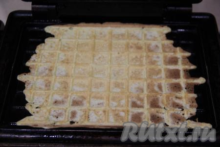 Электровафельницу хорошо разогреть, створки маслом я не смазывала. Выложить на панель вафельницы 2 столовые ложки теста. Плотно закрыть створки вафельницы и выпекать вафельку до золотистого цвета. Готовую вафлю переложить на тарелку. Перед выпечкой каждой следующей вафельки следует перемешивать тесто. Постепенно испечь все вафли. 