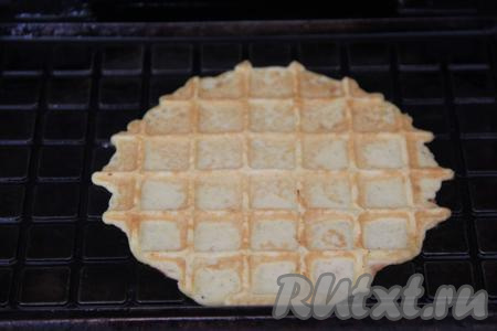 Жарить вафлю до золотистого цвета. Время жарки зависит от температуры разогрева вафельницы, поэтому ориентируйтесь по цвету вафли. Затем переложить на тарелку. Тесто перемешать и постепенно пожарить все вафельки.