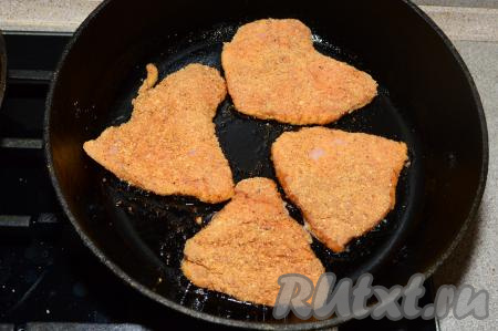 Сковороду поставить на сильный огонь и влить в неё растительное масло. Как только сковорода хорошо разогреется, выложить в один слой куриные отбивные, покрытые панировочными сухарями. Огонь сделать средним и жарить отбивные в течение 2-3 минут (до золотистого цвета).