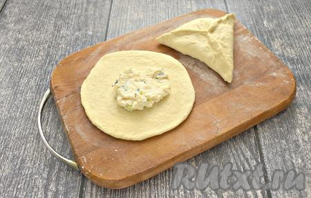 Начинку делим на 6, приблизительно, равных частей (по количеству заготовок теста). В центр каждой раскатанной лепёшки выкладываем одну часть творожно-сырной начинки и скрепляем края в форме треугольника, как на фото, формируя самсу.