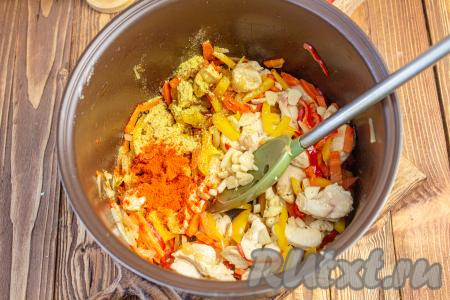 Чеснок очистите и нарежьте тонкими пластинами. Добавьте его в мультиварку, всыпьте приправу для курицы и паприку, перемешайте.