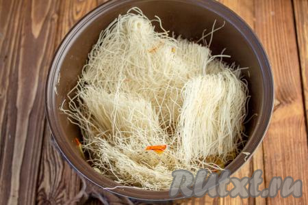 Для удобства фунчозу можно нарезать ножницами на более короткую лапшу. Выложите её в мультиварку к овощам и курице.